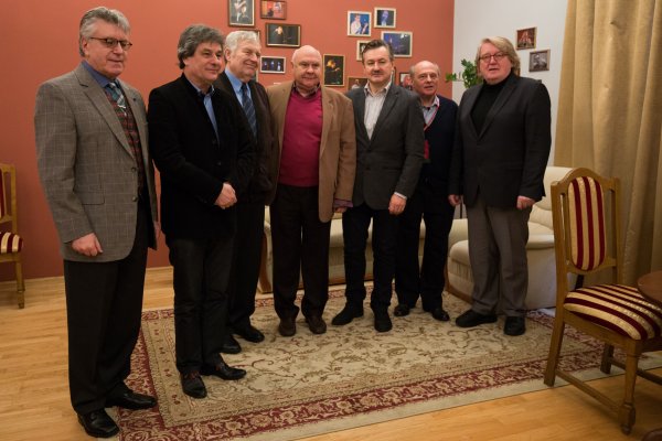 siedmiu mężczyzn pozuje do fotografii stojąc na dywanie