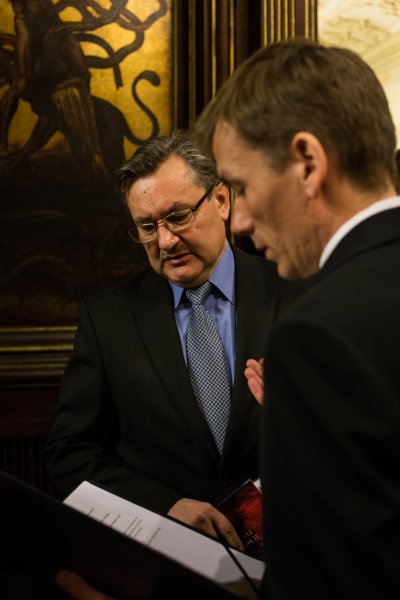 dwaj mężczyźni rozmawiają pochyleni nad kartką