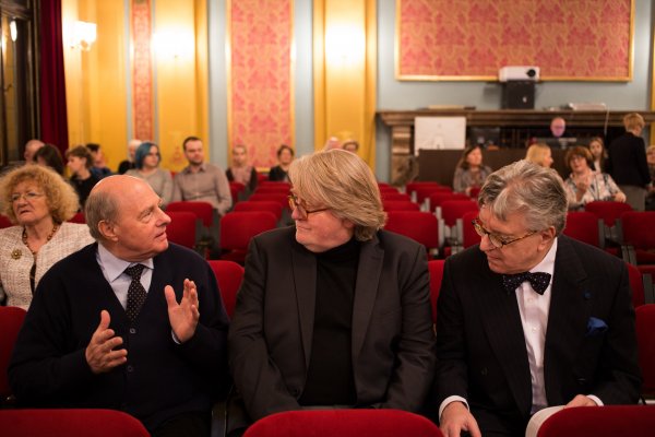 trzej starsi mężczyźni rozmawiają w fotelach publiczności