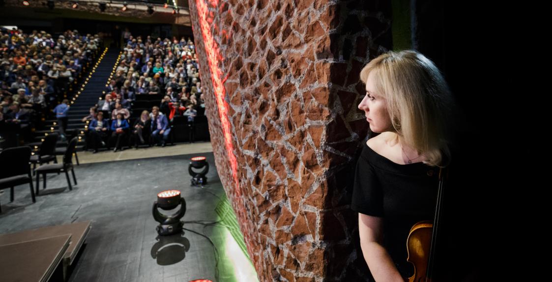 Skrzypaczka spoglądająca na wypełnioną publiczność
