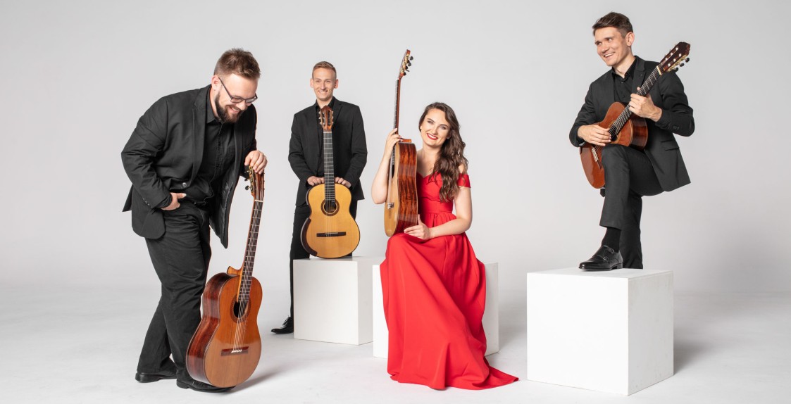 trzech elegancko ubranych gitarzystów oraz gitarzystka ubrana w czerwoną długa suknię