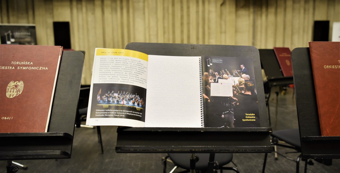 otwarte książki stojące na pulpicie