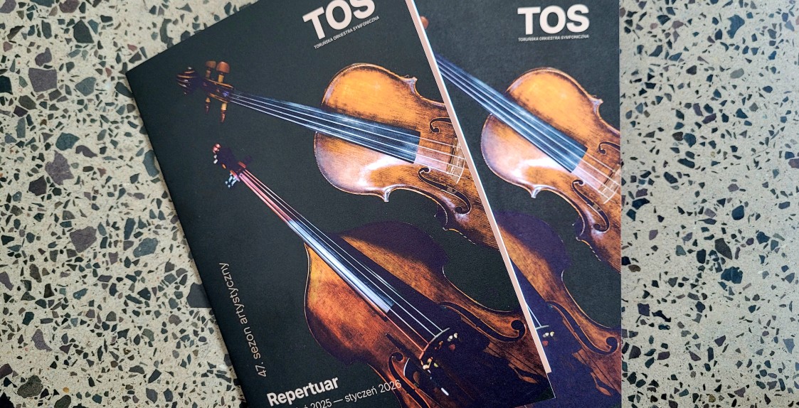 Na zdjęciu widać dwa papierowe repertuary TOS na sezon artystyczny 2025/2026, na okładce na czarnym tle widać skrzypce i kontrabas