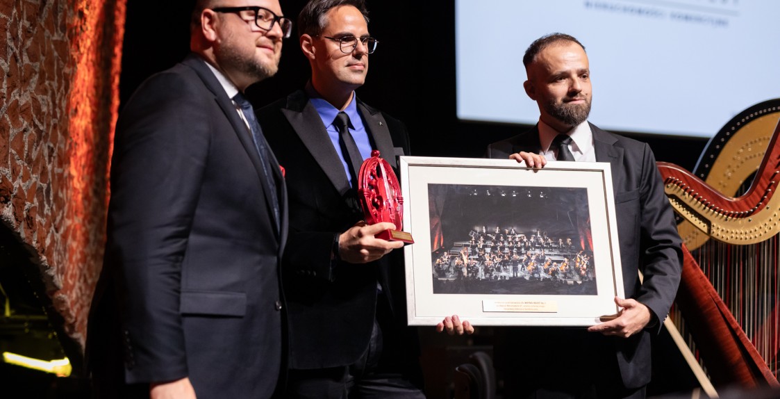 trzech mężczyzna na scenie trzymających obraz i statuetkę Muzy TOS