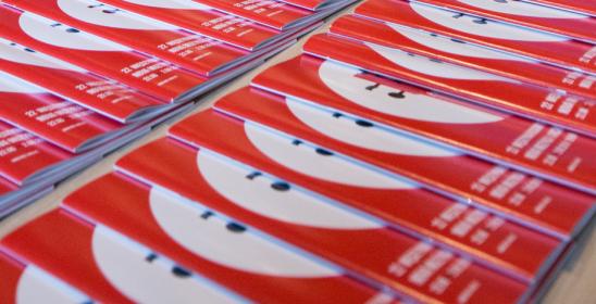 katalogi ułożone na stole przed wejściem na salę koncertową 