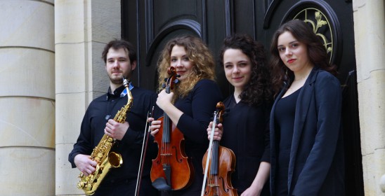 trzy kobiety i mężczyzna trzymający instrumenty