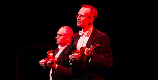 dwóch mężczyzn grających na skrzypcach