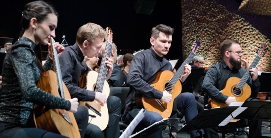 kobieta i trzech mężczyzn grających na gitarach