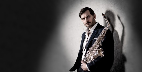 mężczyzna trzymający w rękach saksofon