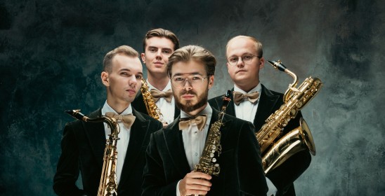 czterech mężczyzn trzymających saksofony