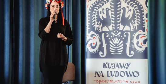 kobieta ubrana na czarno w wianku kujawskim obok grafiki projektu