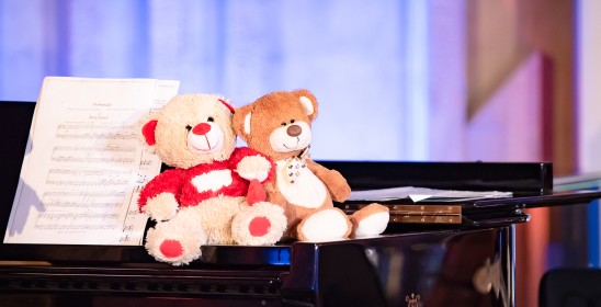 dwa pluszowe misie siedzące na fortepianie
