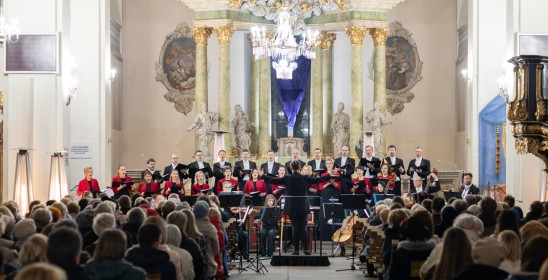 osoby siedzące w kościelnych ławkach, w tle chór