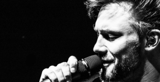 portret mężczyzny śpiewającego do mikrofonu