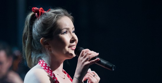 portret kobiety śpiewającej do mikrofonu