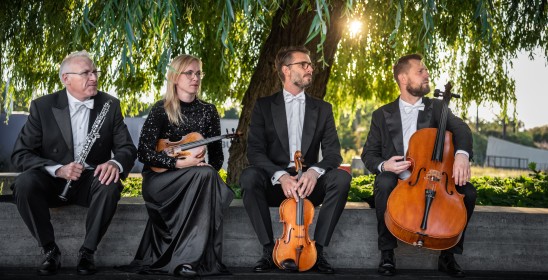 trzech meżczyzn i kobieta trzymający instrumenty muzyczne