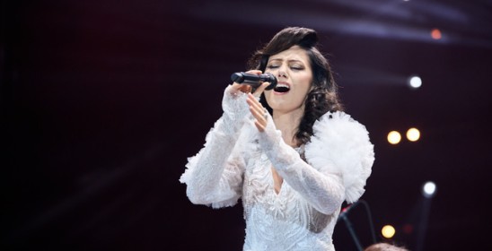 kobieta w białej sukni śpiewa do mikrofonu