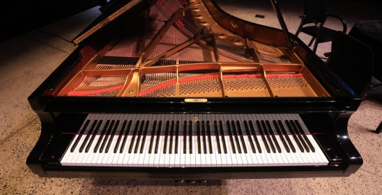 fortepian z otwartą klapą widoczny od strony klawiatury