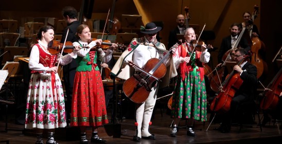 trzy kobiety i mężczyzna w strojach góralskich grają na instrumentach muzycznych