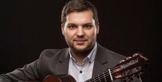 mężczyzna trzymający gitarę