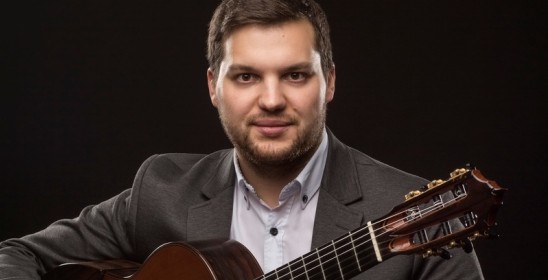 mężczyzna trzymający gitarę