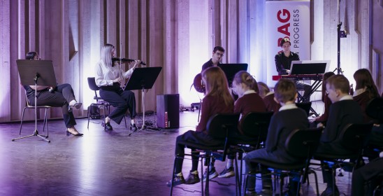 grupa muzyków grająca przed dziecięcą widownią
