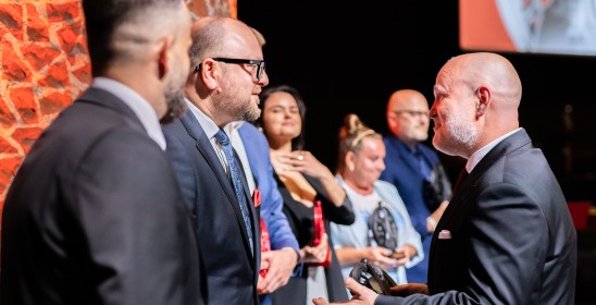 prezydent Torunia i dyrektor orkiestry wręczają statuetkę muzę TOS-u grafikowi Jarosławowi Pawlickiemu