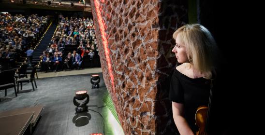 Skrzypaczka spoglądająca na wypełnioną publiczność