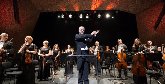 Orkiestra z dyrygentem na scenie