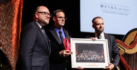 trzech mężczyzna na scenie trzymających obraz i statuetkę Muzy TOS