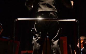 dyrygent stojący na podeście tyłem