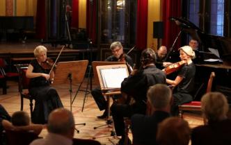 kwartet smyczkowy gra, z nimi mężczyzna gra na fortepianie