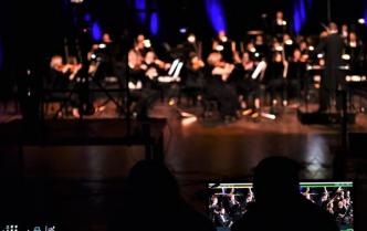 Orkiestra -kobiety i mężczyźni grają na instrumentach koncert symfoniczny na scenie sali koncertowej CKK Jordanki