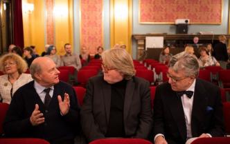 trzej starsi mężczyźni rozmawiają w fotelach publiczności