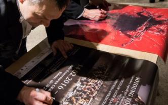 dwaj mężczyźni podpisujący się na plakatach