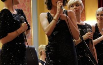 cztery kobiety w sukniach z mikrofonami