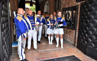 people in white and blue uniforms standing at the gate