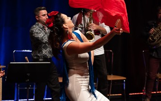 a woman in a white dress with yellow and red fabric outstretched