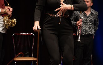 woman in black pants and a blouse and red shoes