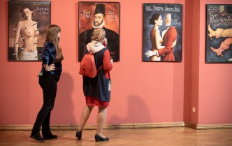 dwie kobiety oglądające plakaty wiszące na ścianie
