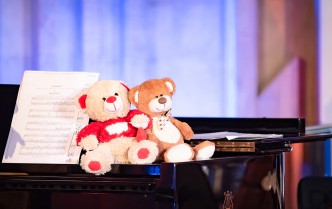 dwa misie siedzące na fortepianie