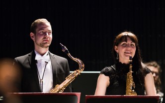 mężczyzna trzymający saksofon tenorowy i kobieta trzymająca saksofon sopranowy