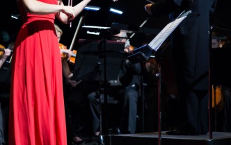 kobieta w czcerwonej sukni grająca na skrzypcach