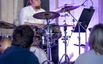 mężczyzna grający na zestawie perkusyjnym