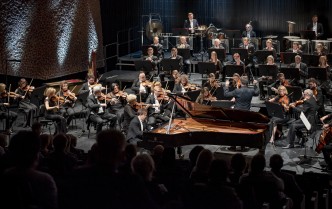 pianista grający na fortepianie i orkiestra na scenie