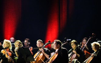 orkiestra smyczkowa w dolnej części, w górnej ciemnoczerwone tło