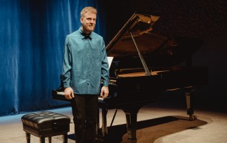 mężczyzna stojący obok fortepianu
