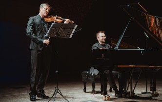 mężczyzna grający na skrzypcach i mężczyzna grający na fortepianie