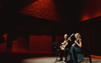 kobieta i mężczyzna grający na gitarach