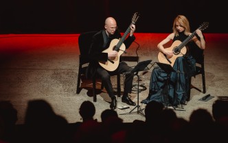 kobieta i mężczyzna grający na gitarach